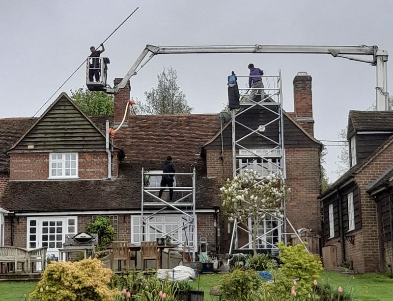 The Moss Cleaners using cherry picker and scaffolding to clean roof safely and professionally in Cranleigh, Surrey